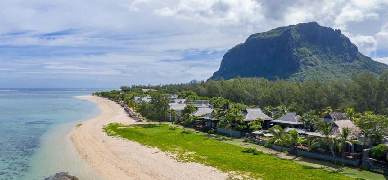 Vista aérea de The St. Regis Le Morne Resort, con piscina, jardines tropicales, playa y la montaña Le Morne Brabant.